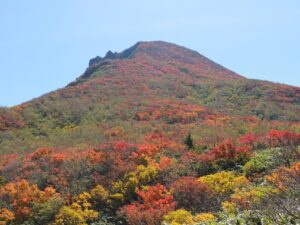 紅葉に染まる登山道から磐梯山の山頂を目指す登山者