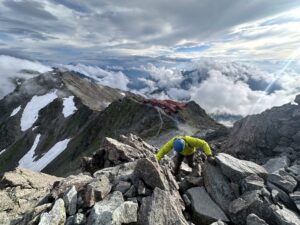 槍ヶ岳の穂先を登る登山者と眼下の槍ヶ岳山荘