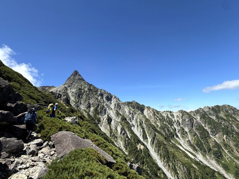 上高地から槍ヶ岳へ向かう登山者と青空にそびえる槍の穂先