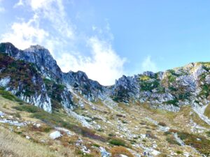 青空にそびえる宝剣岳の岩峰を見上げる